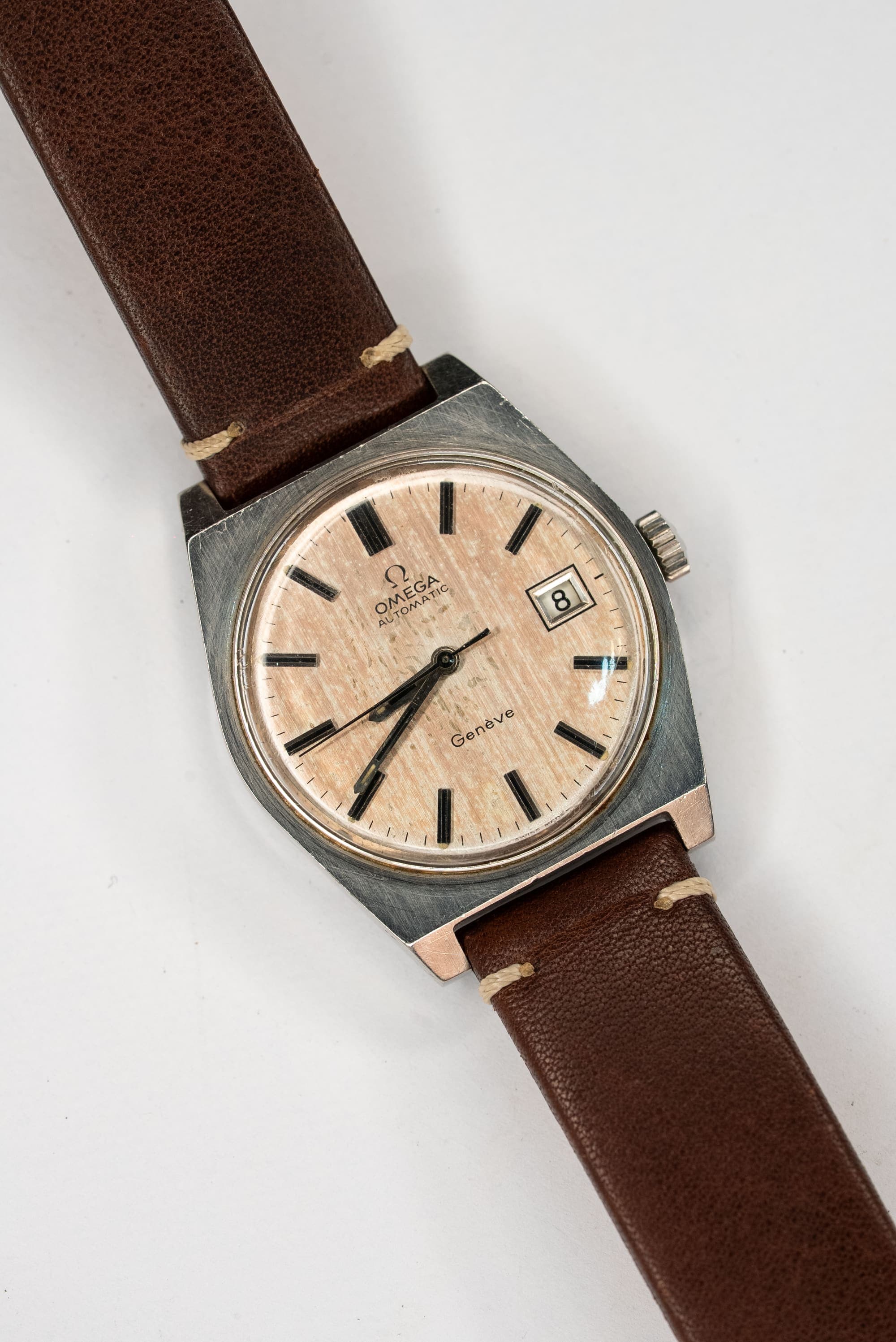 A vintage Omega with a linen dial on a tan leather strap