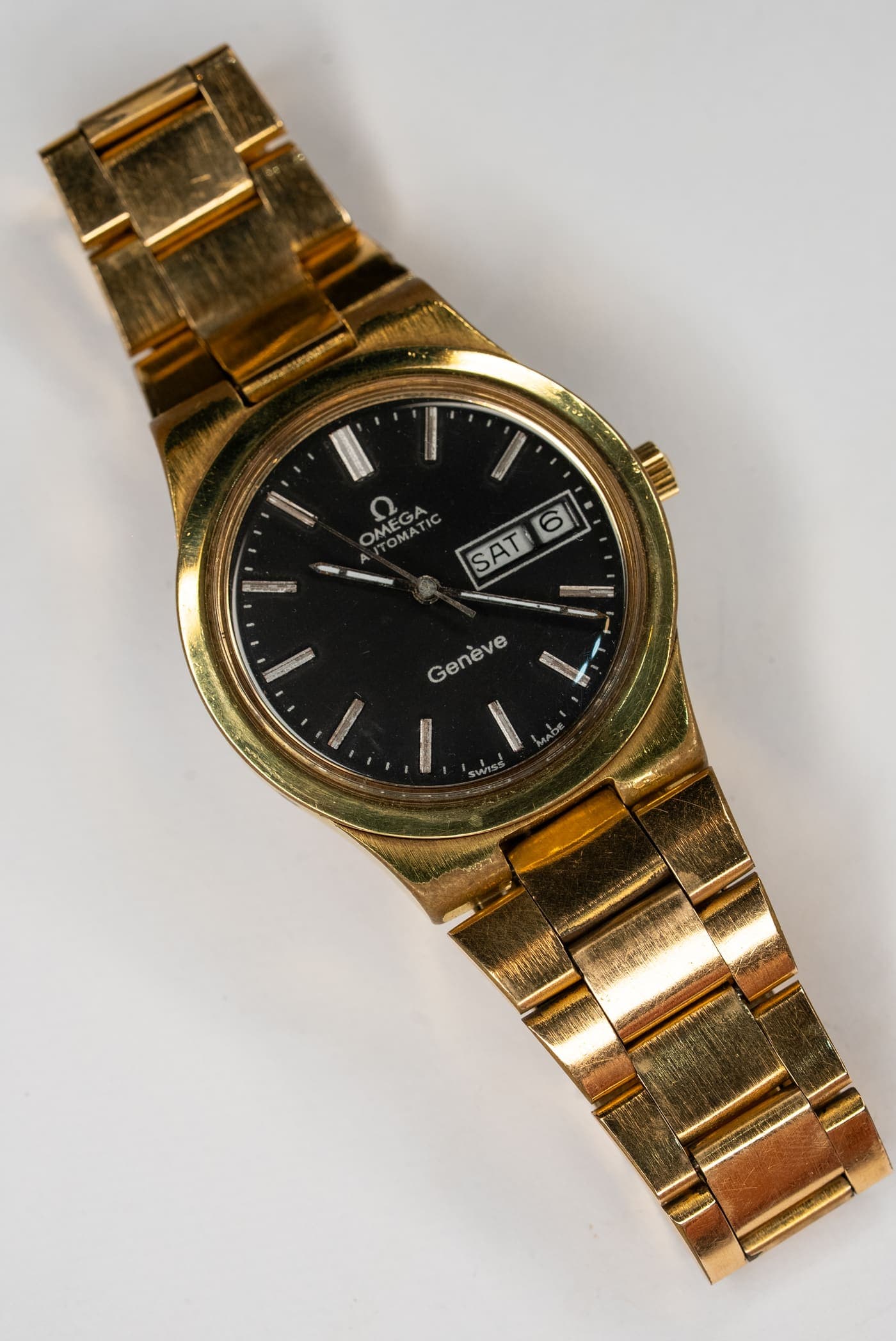A gold vintage Omega with a black dial