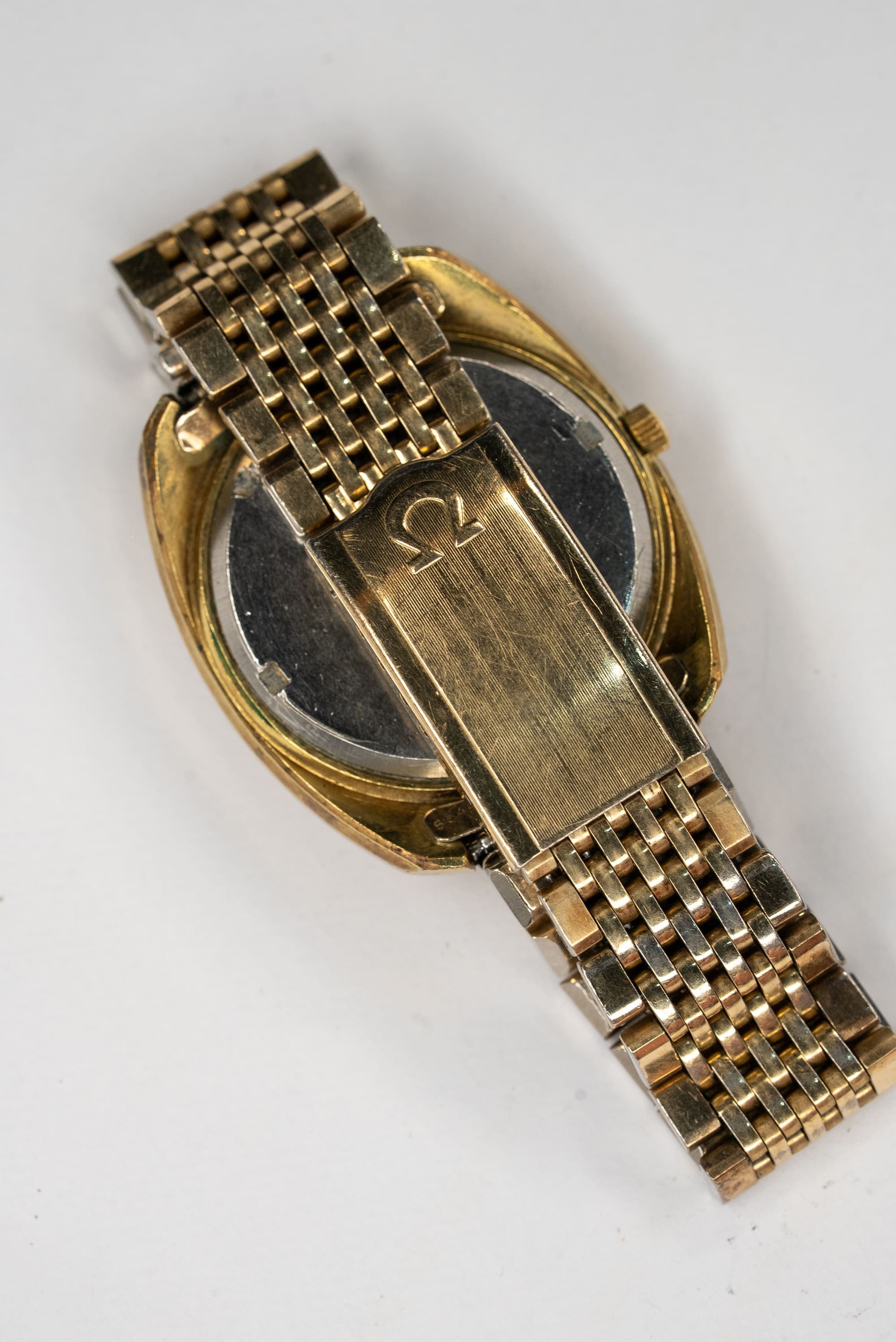 A vintage Omega on a steel bracelet, seen from the case back